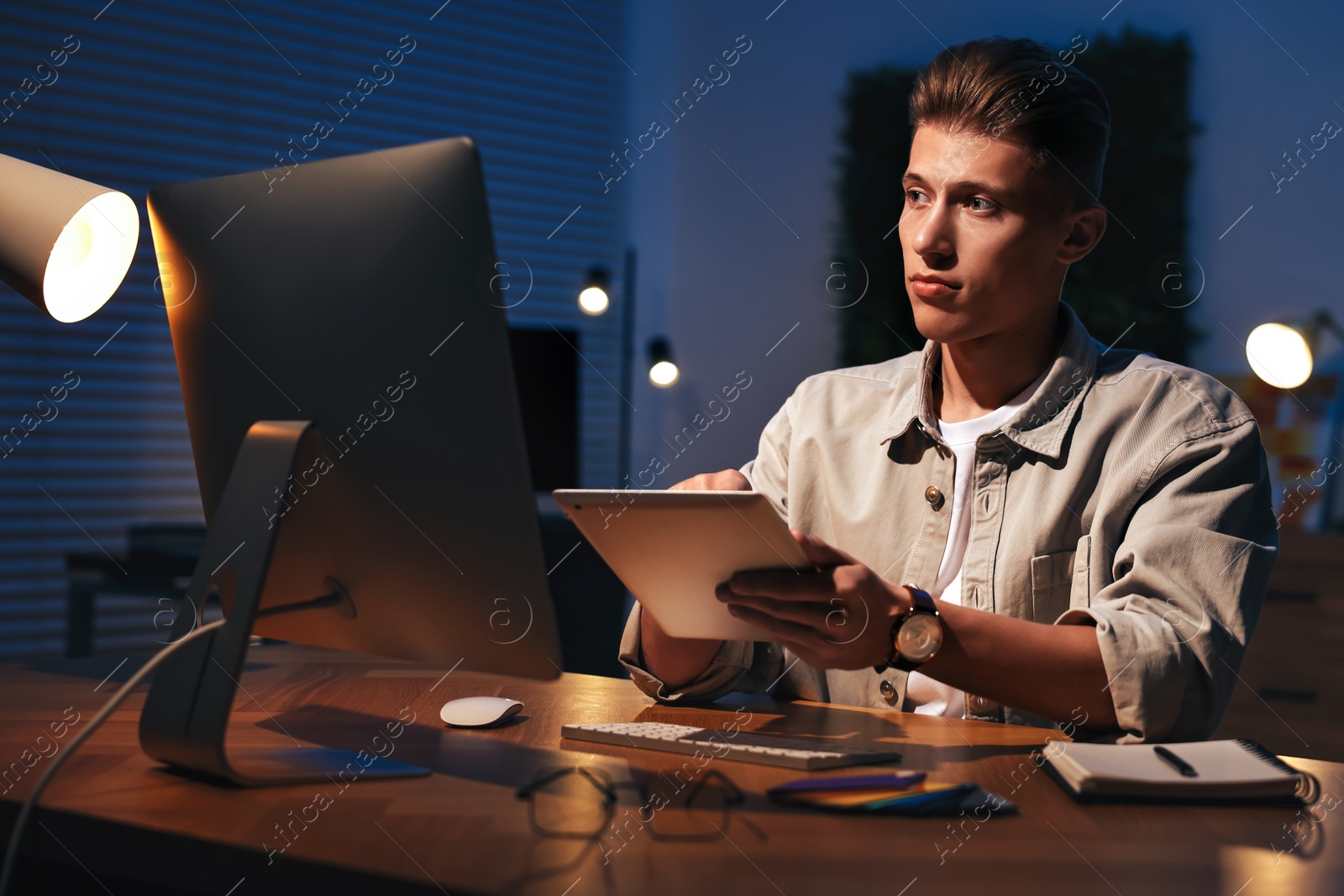 Photo of Designer working on tablet indoors at night