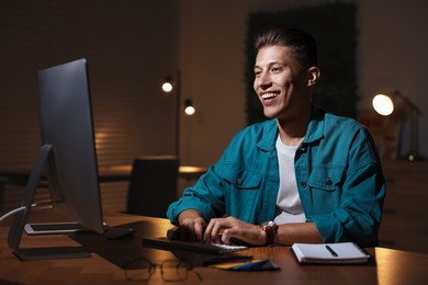 Photo of Designer working on computer indoors at night