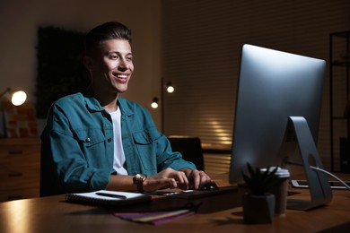 Photo of Designer working on computer indoors at night