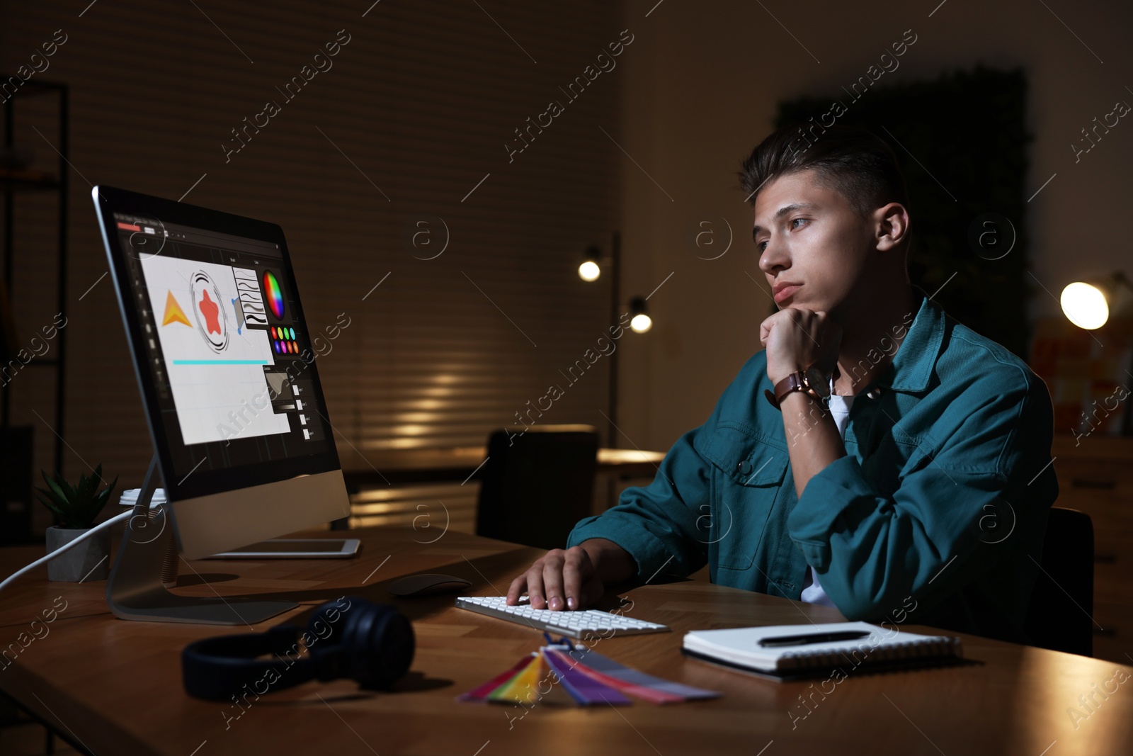 Photo of Designer working on computer indoors at night