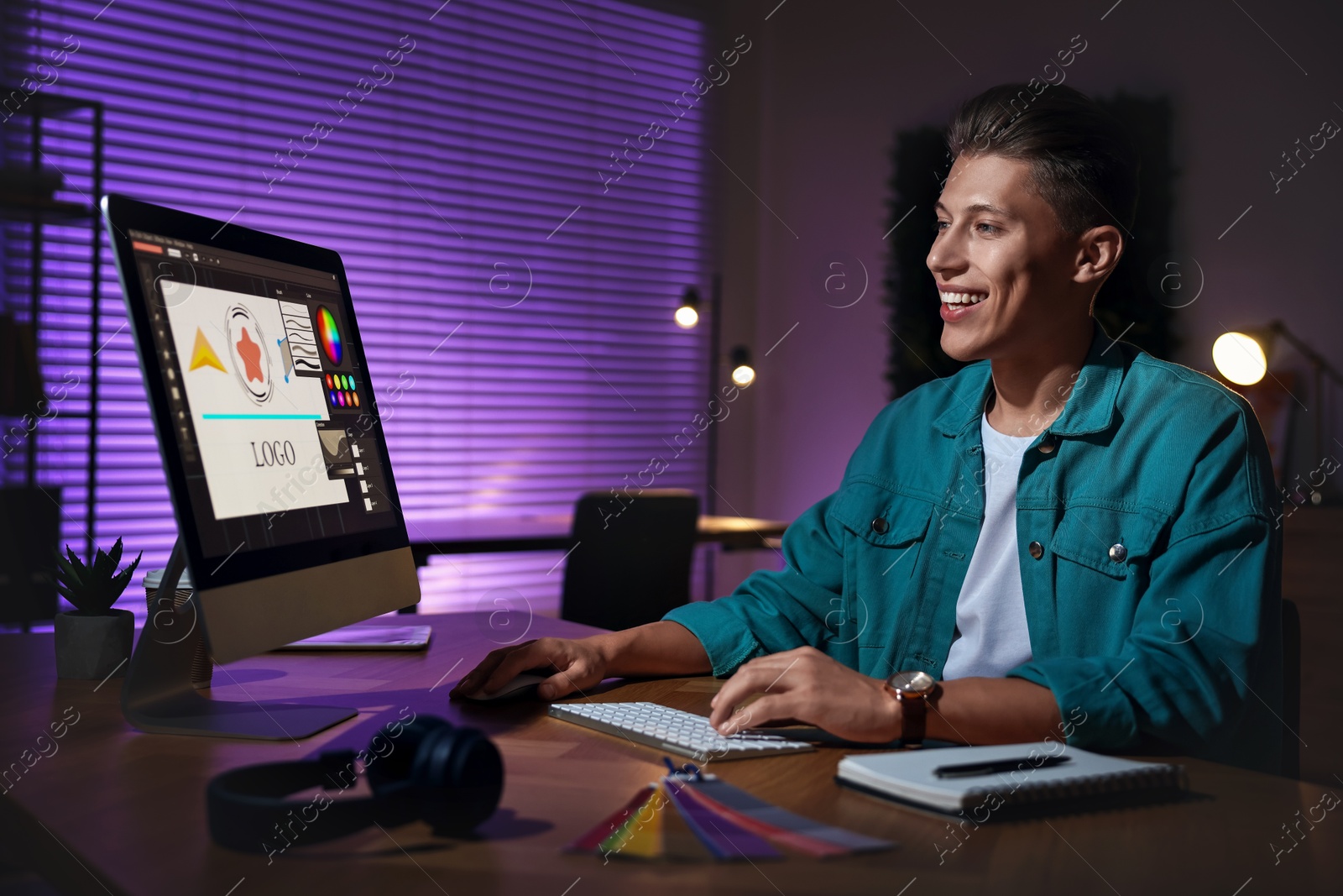 Photo of Designer working on computer indoors at night