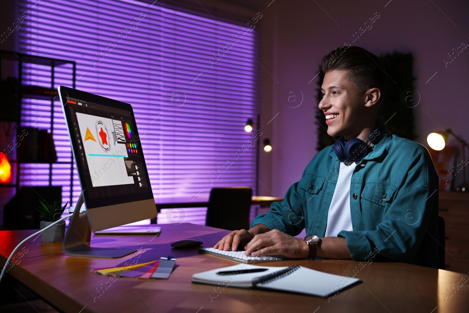 Photo of Designer working on computer indoors at night