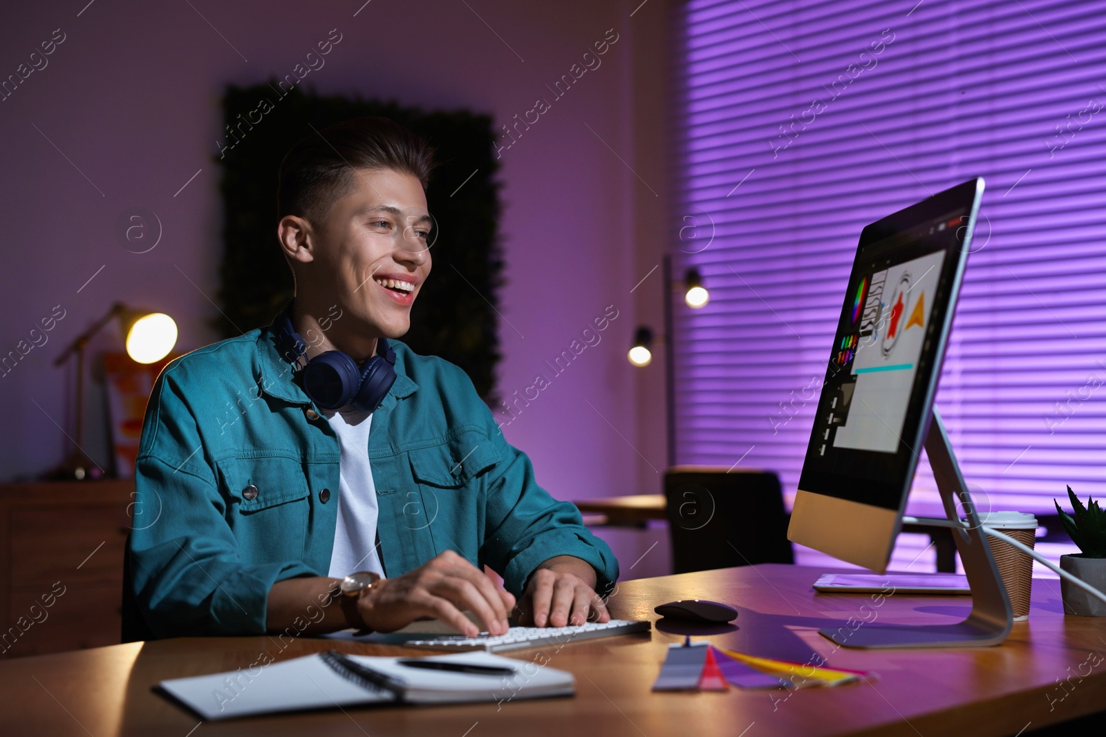 Photo of Designer working on computer indoors at night