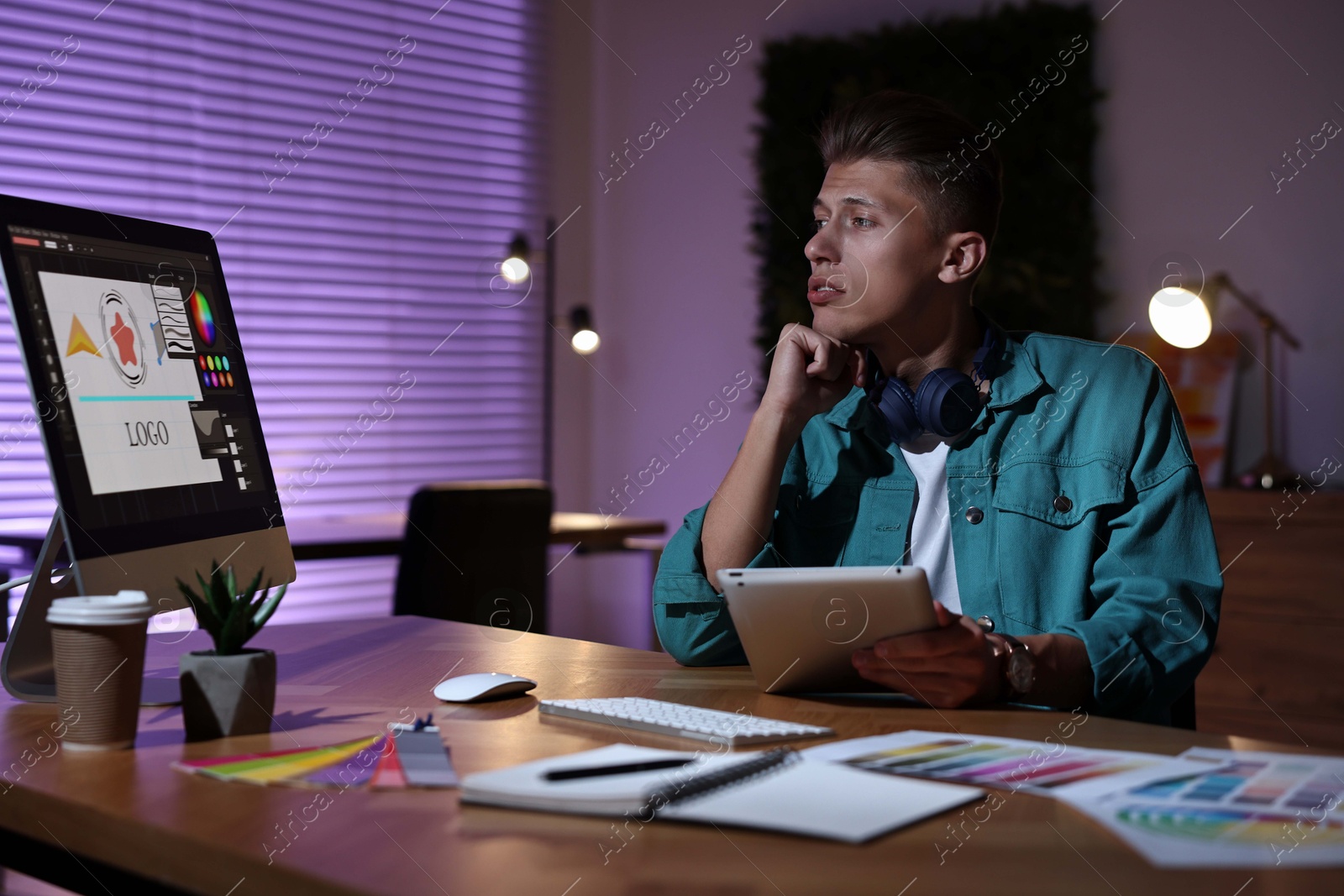 Photo of Designer with tablet working indoors at night