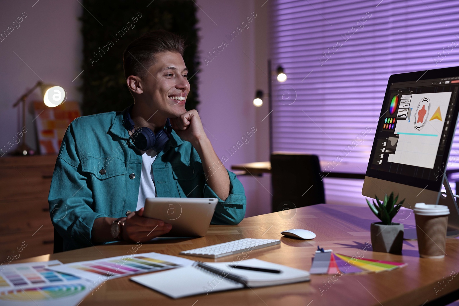 Photo of Designer with tablet working indoors at night