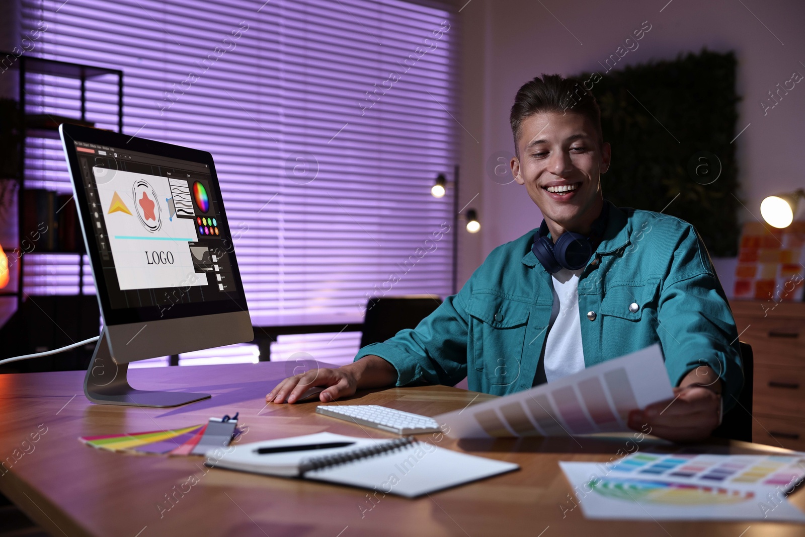 Photo of Designer with color palette working indoors at night