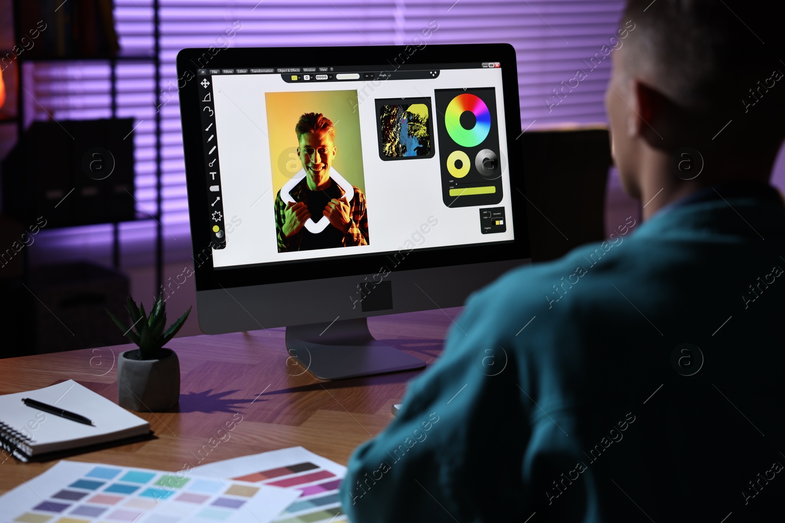 Photo of Designer working on computer indoors at night