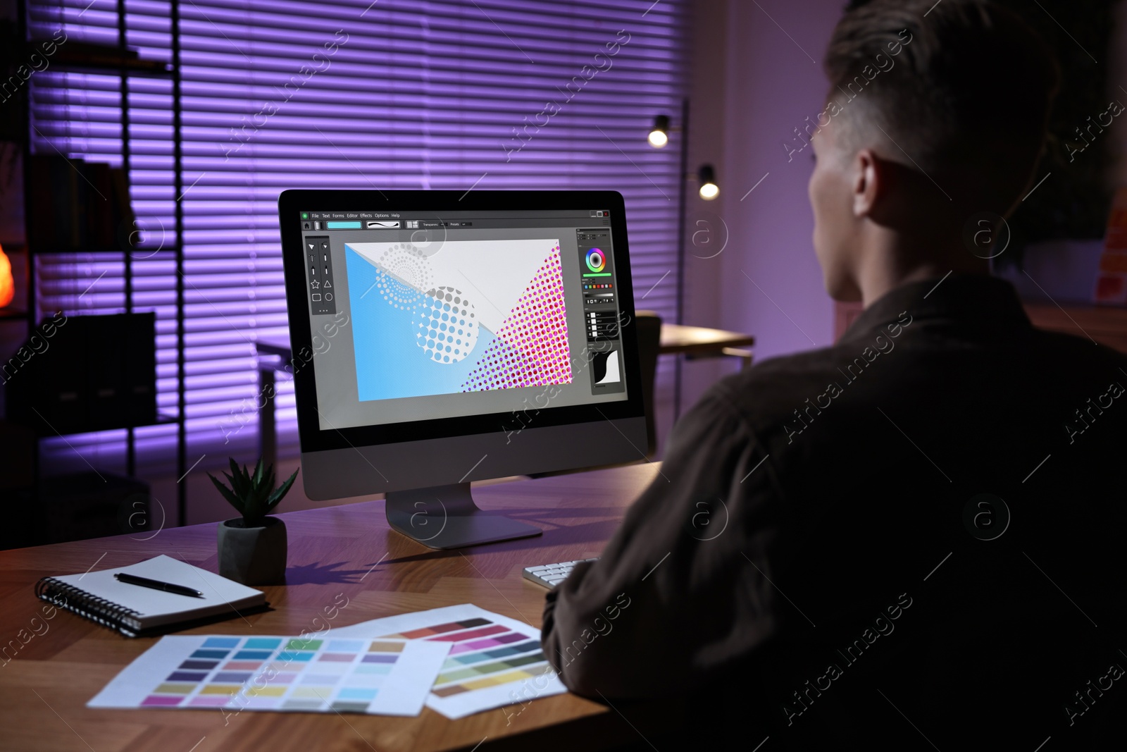 Photo of Designer working on computer indoors at night