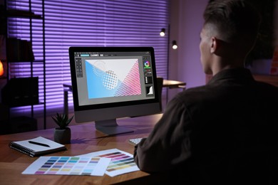 Photo of Designer working on computer indoors at night