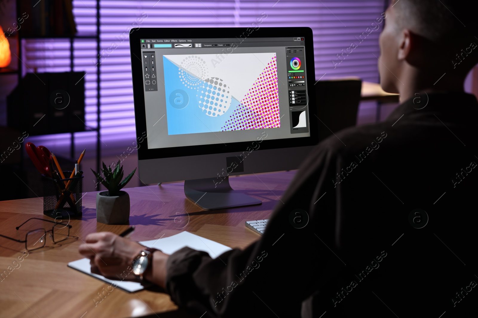 Photo of Designer working on computer indoors at night