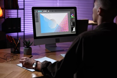 Photo of Designer working on computer indoors at night