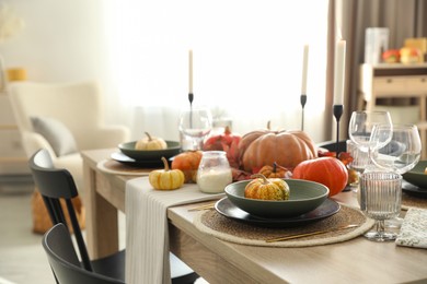 Photo of Stylish table setting with beautiful autumn decor in dining room