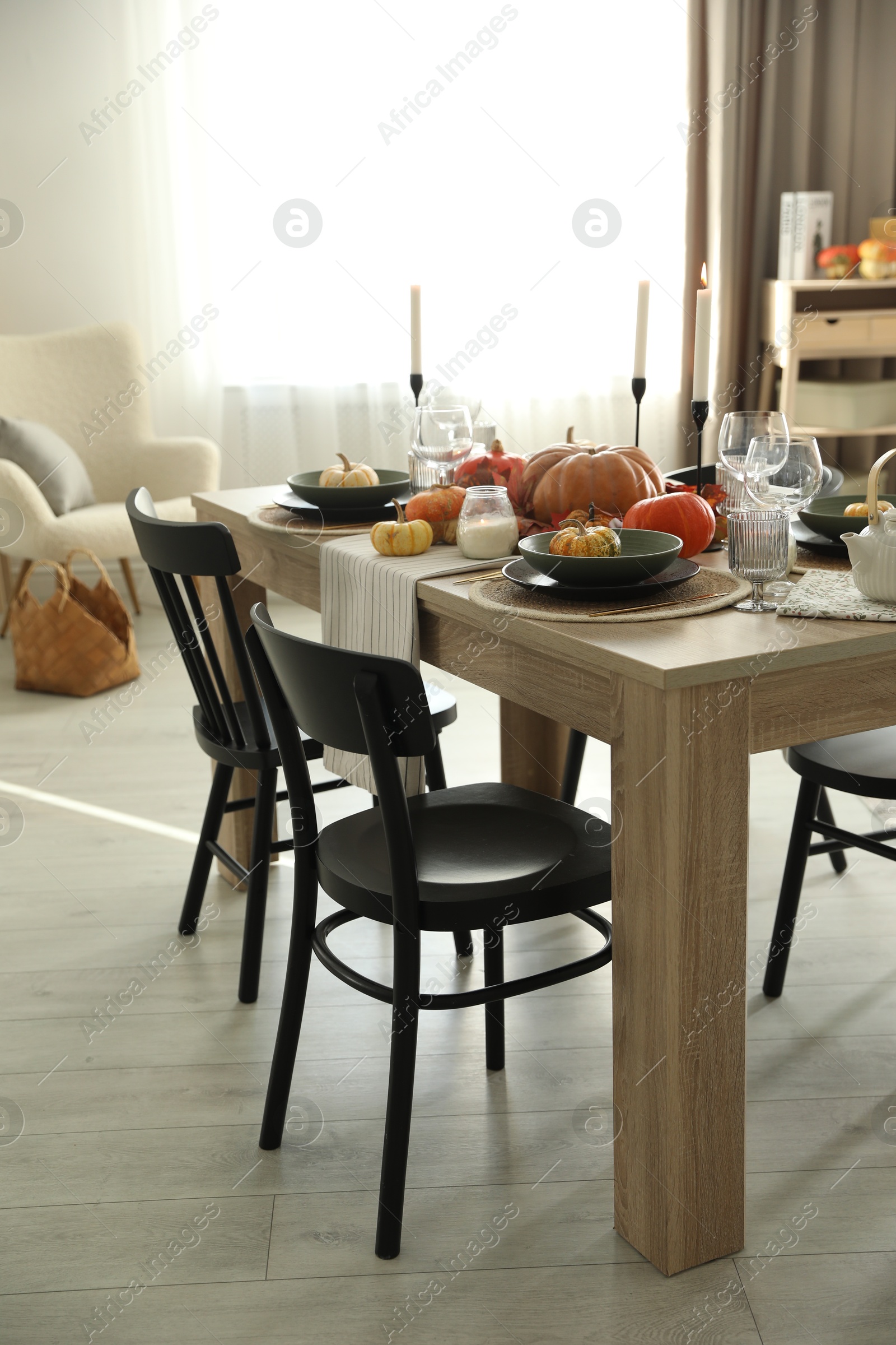 Photo of Stylish dining room with beautiful table setting and autumn decor