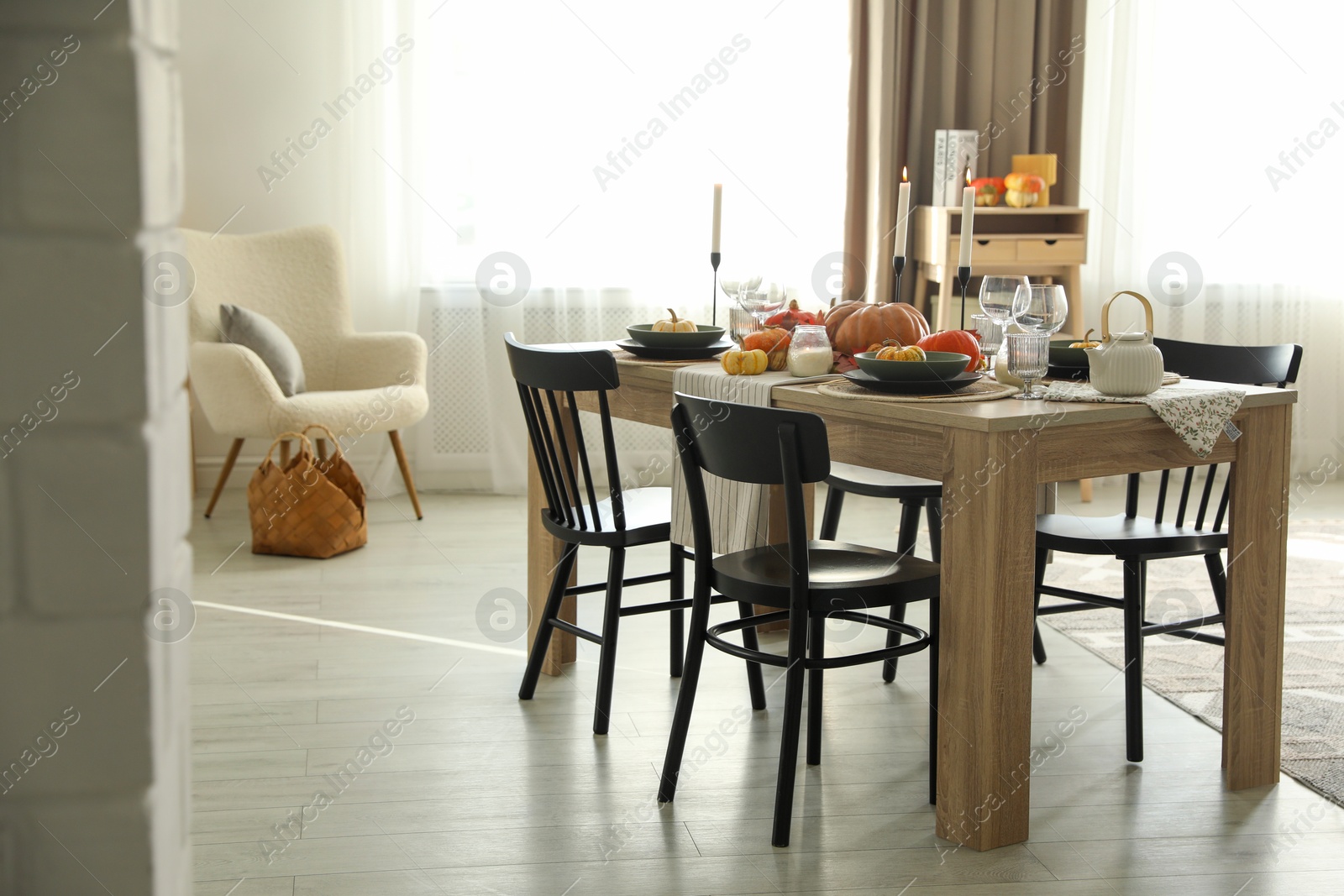 Photo of Stylish dining room with beautiful table setting and autumn decor