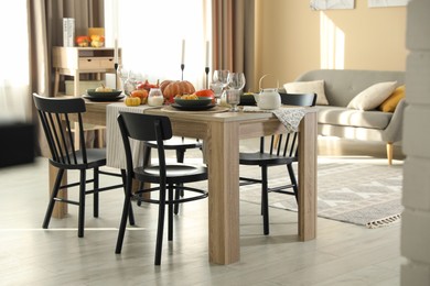 Photo of Stylish dining room with beautiful table setting and autumn decor