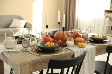 Photo of Stylish table setting with beautiful autumn decor in dining room