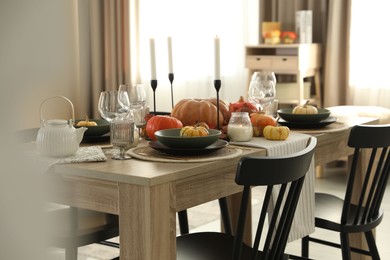 Stylish table setting with beautiful autumn decor in dining room