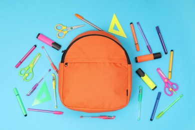 Photo of Backpack and different school supplies on light blue background, flat lay