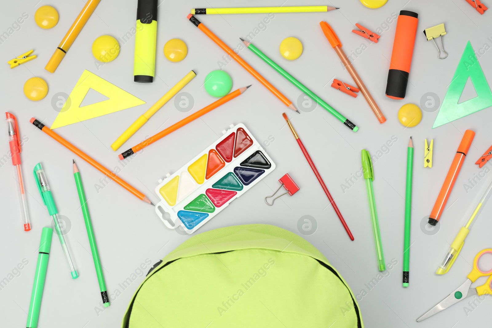 Photo of Backpack and different school supplies on light gray background, flat lay