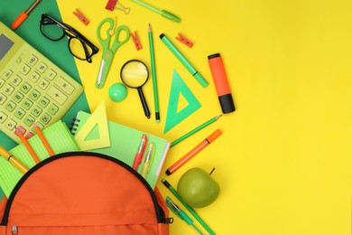 Backpack and different school supplies on color background, flat lay. Space for text