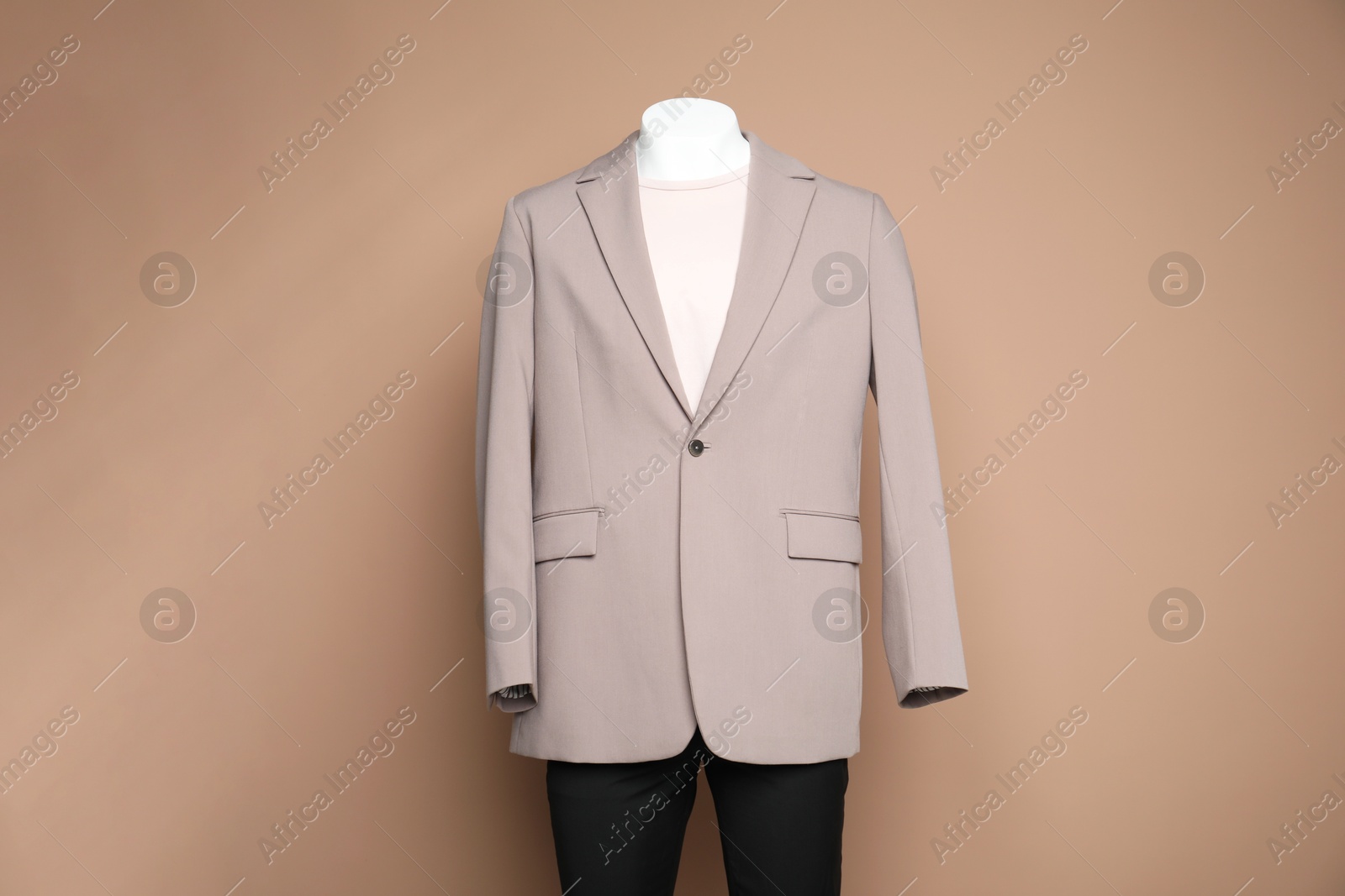 Photo of Male mannequin with stylish outfit on light brown background