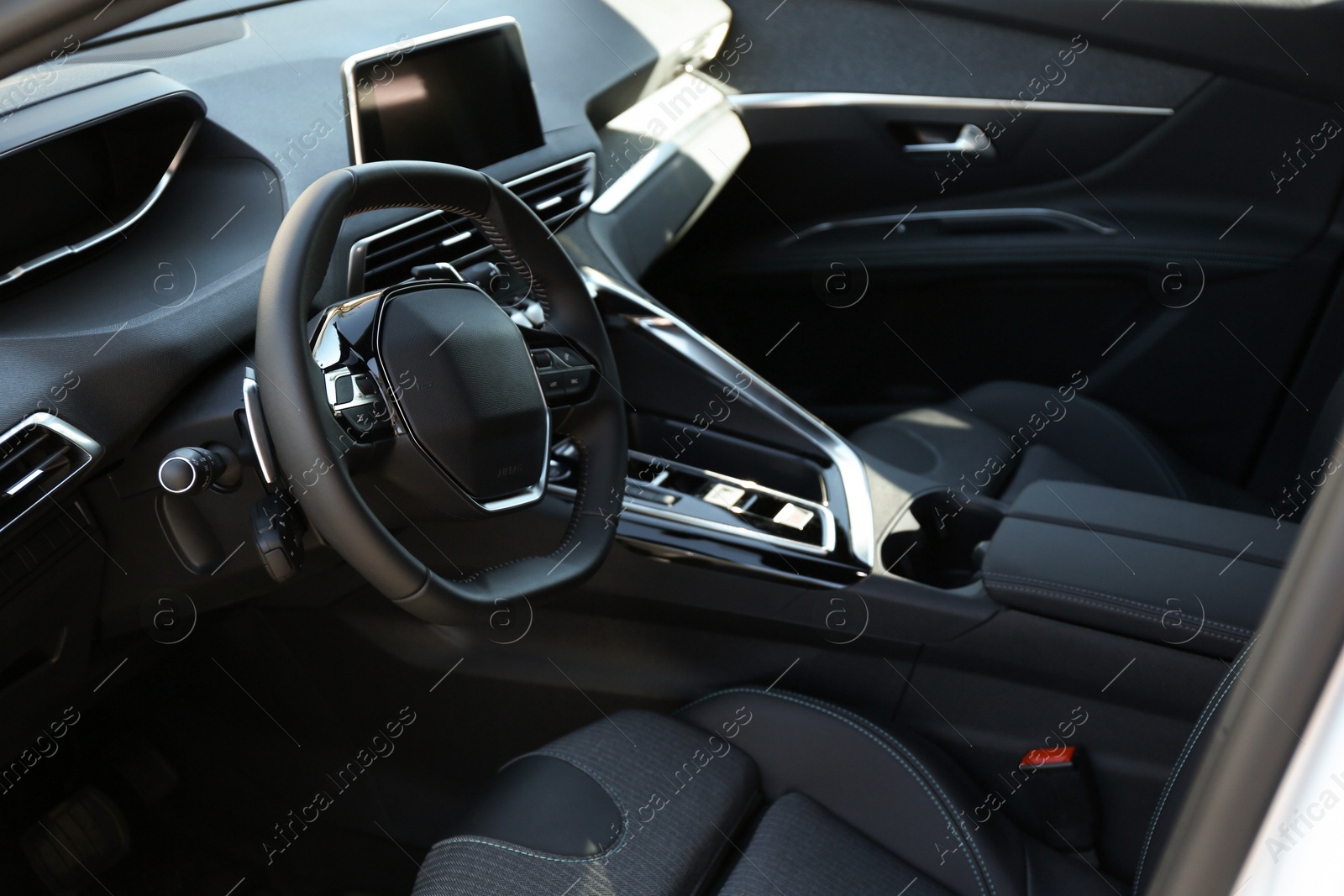 Photo of Steering wheel and dashboard inside of modern luxury car, closeup