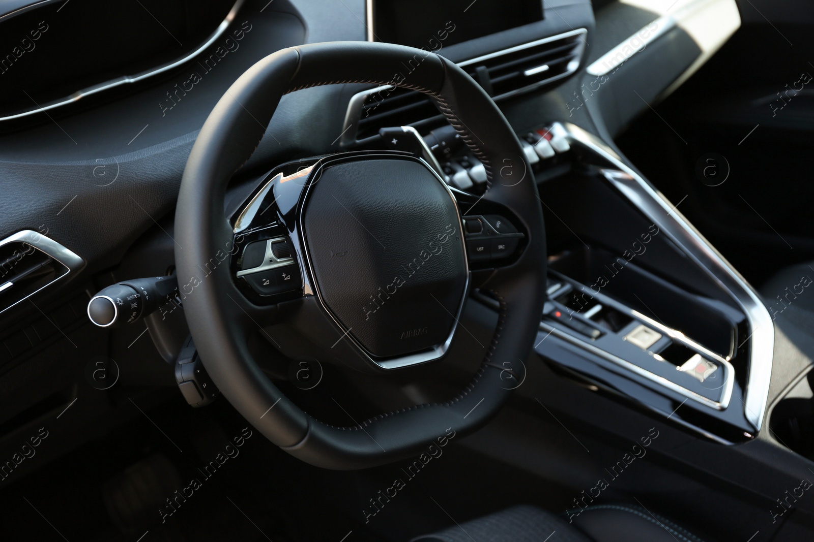 Photo of Steering wheel and dashboard inside of modern luxury car, closeup