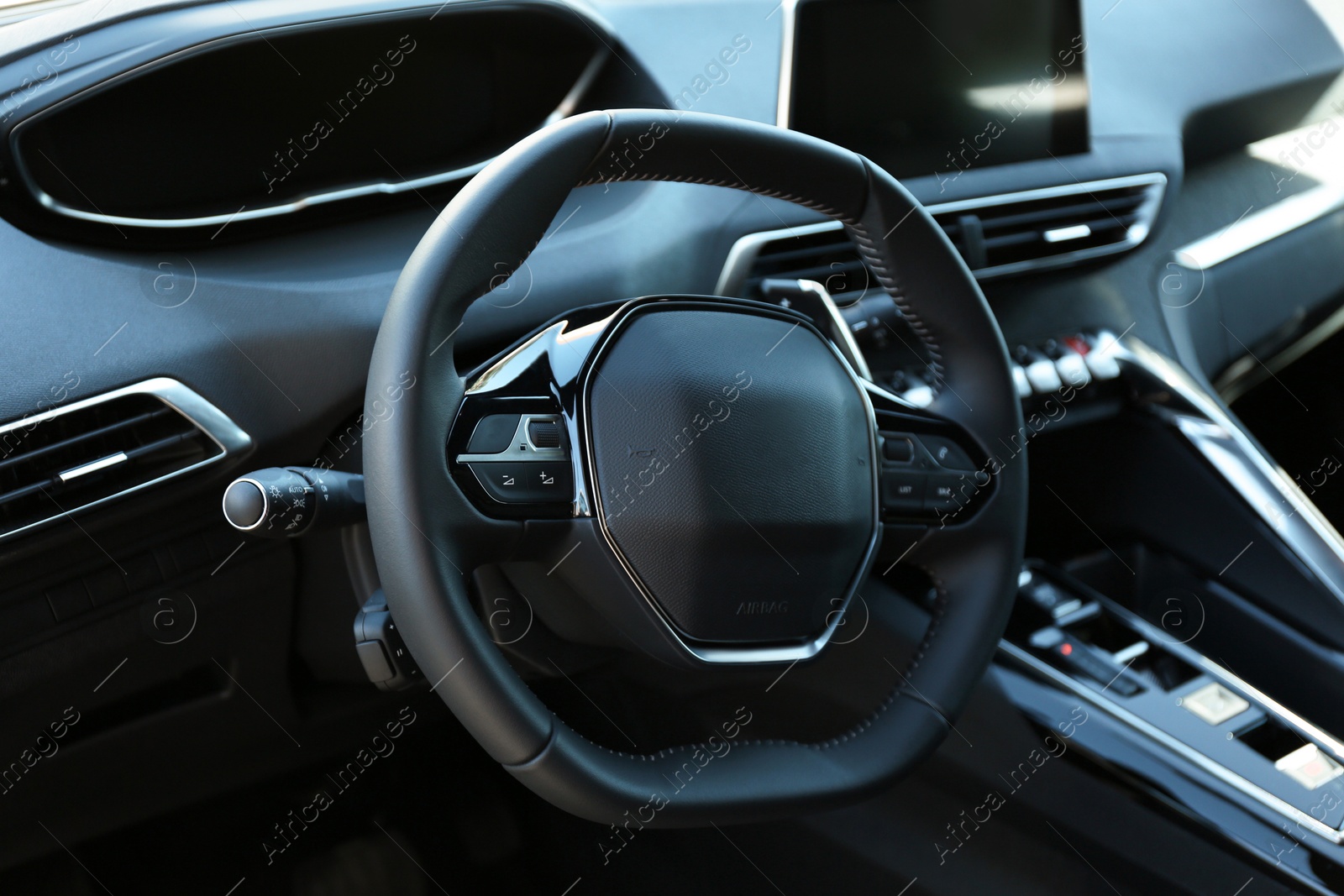 Photo of Steering wheel and dashboard inside of modern luxury car, closeup