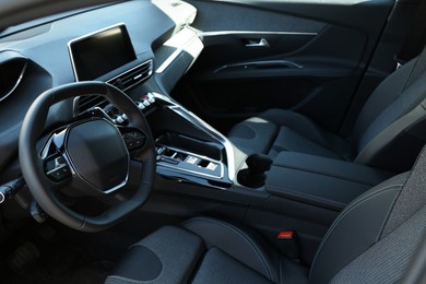 Photo of Steering wheel and dashboard inside of modern luxury car, closeup