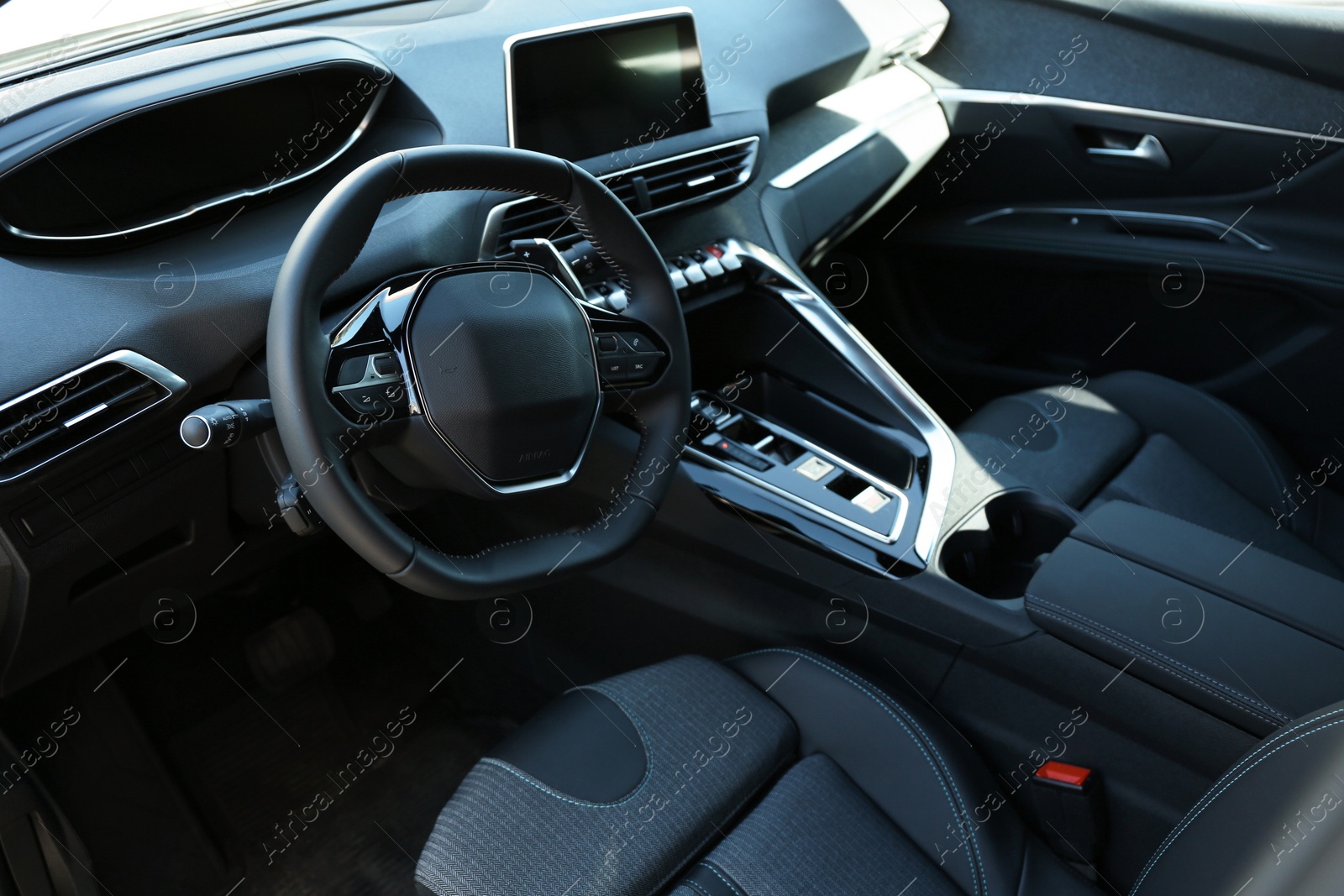 Photo of Steering wheel and dashboard inside of modern luxury car, closeup