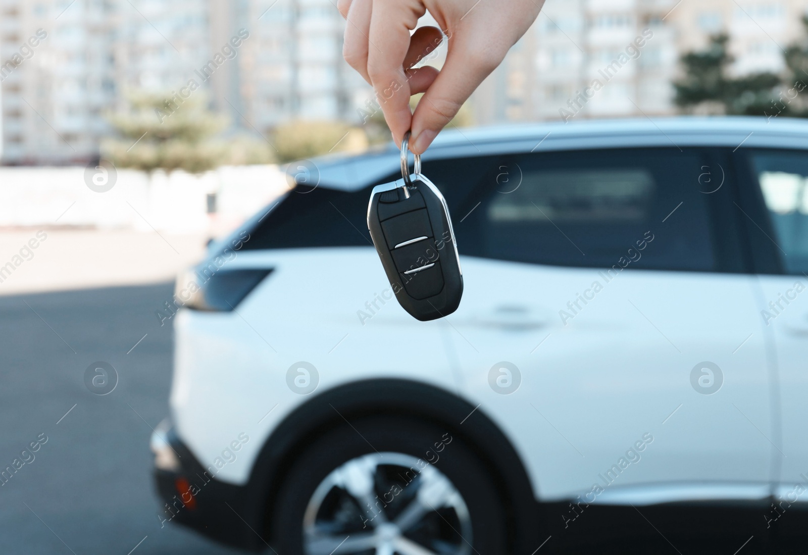 Photo of Woman holding key near car outdoors, closeup