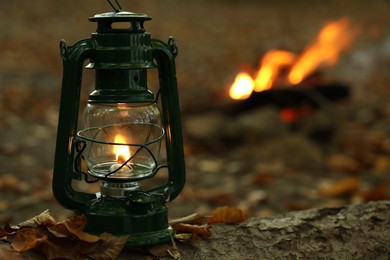 Photo of Vintage kerosene lamp in forest at evening, space for text