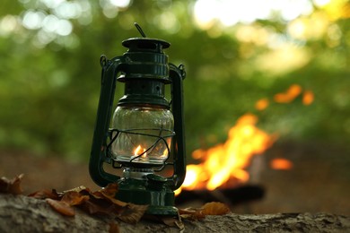 Photo of Vintage kerosene lamp in forest at evening, space for text