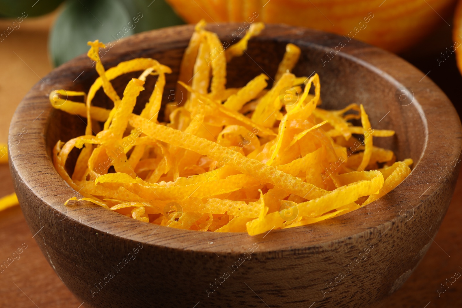 Photo of Fresh orange zest in wooden bowl, closeup