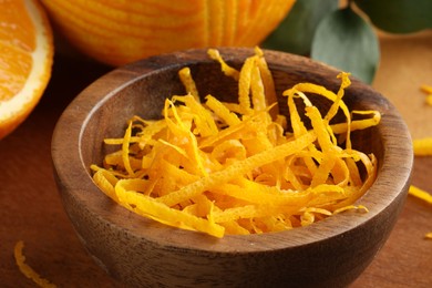 Photo of Fresh orange zest in wooden bowl, closeup