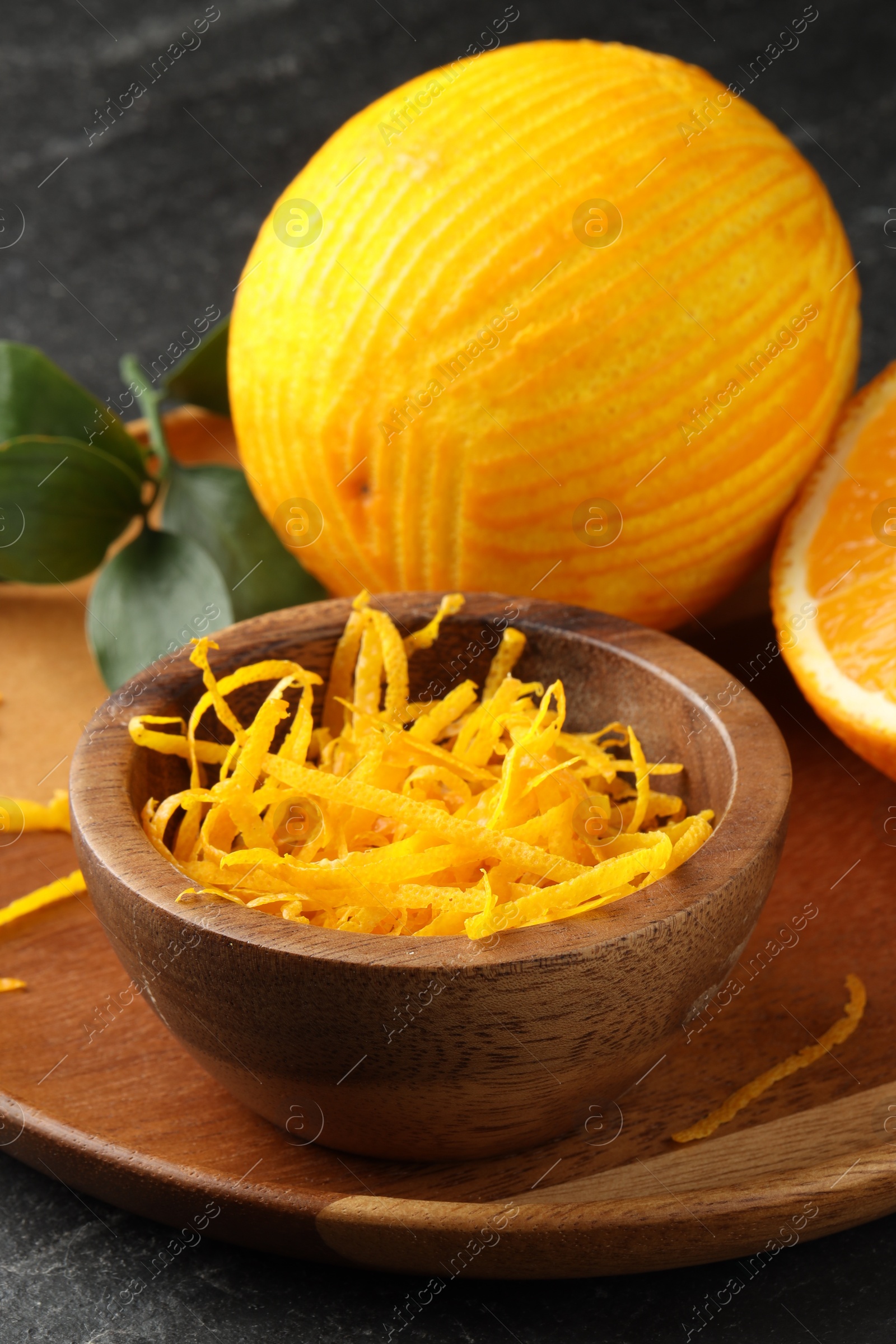 Photo of Fresh orange zest and fruit on black table