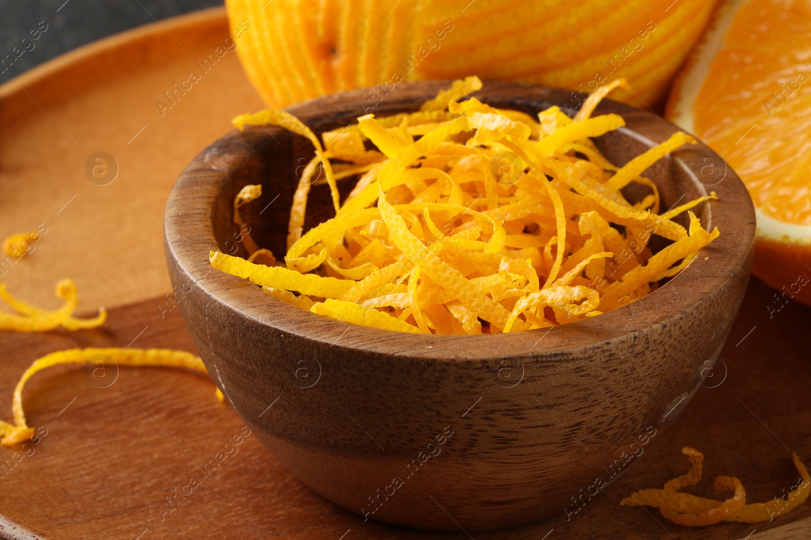 Photo of Fresh orange zest in wooden bowl, closeup