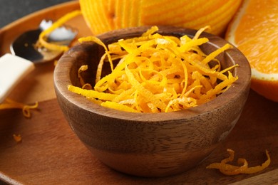 Photo of Fresh orange zest in wooden bowl, closeup