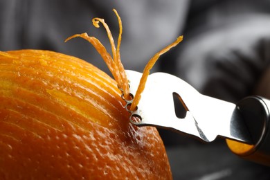 Photo of Zesting fresh orange at table, closeup view