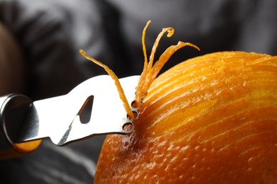 Photo of Zesting fresh orange at table, closeup view