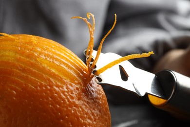 Photo of Zesting fresh orange at table, closeup view