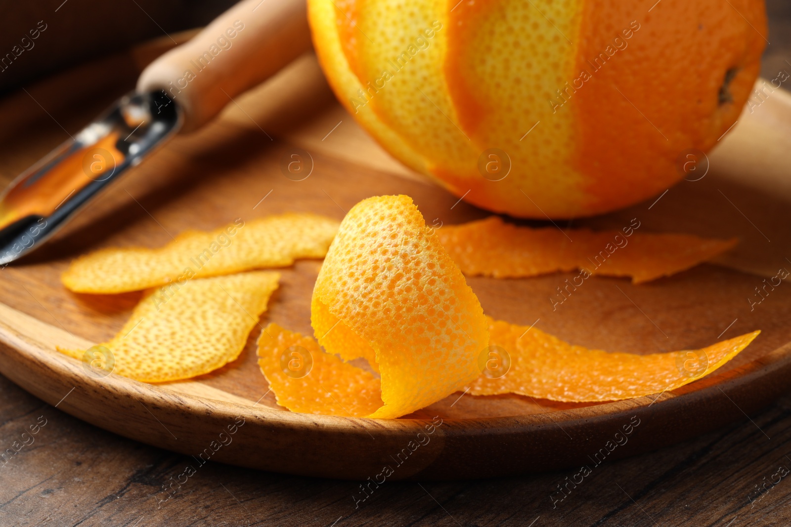 Photo of Fresh orange peel and fruit on wooden table, closeup