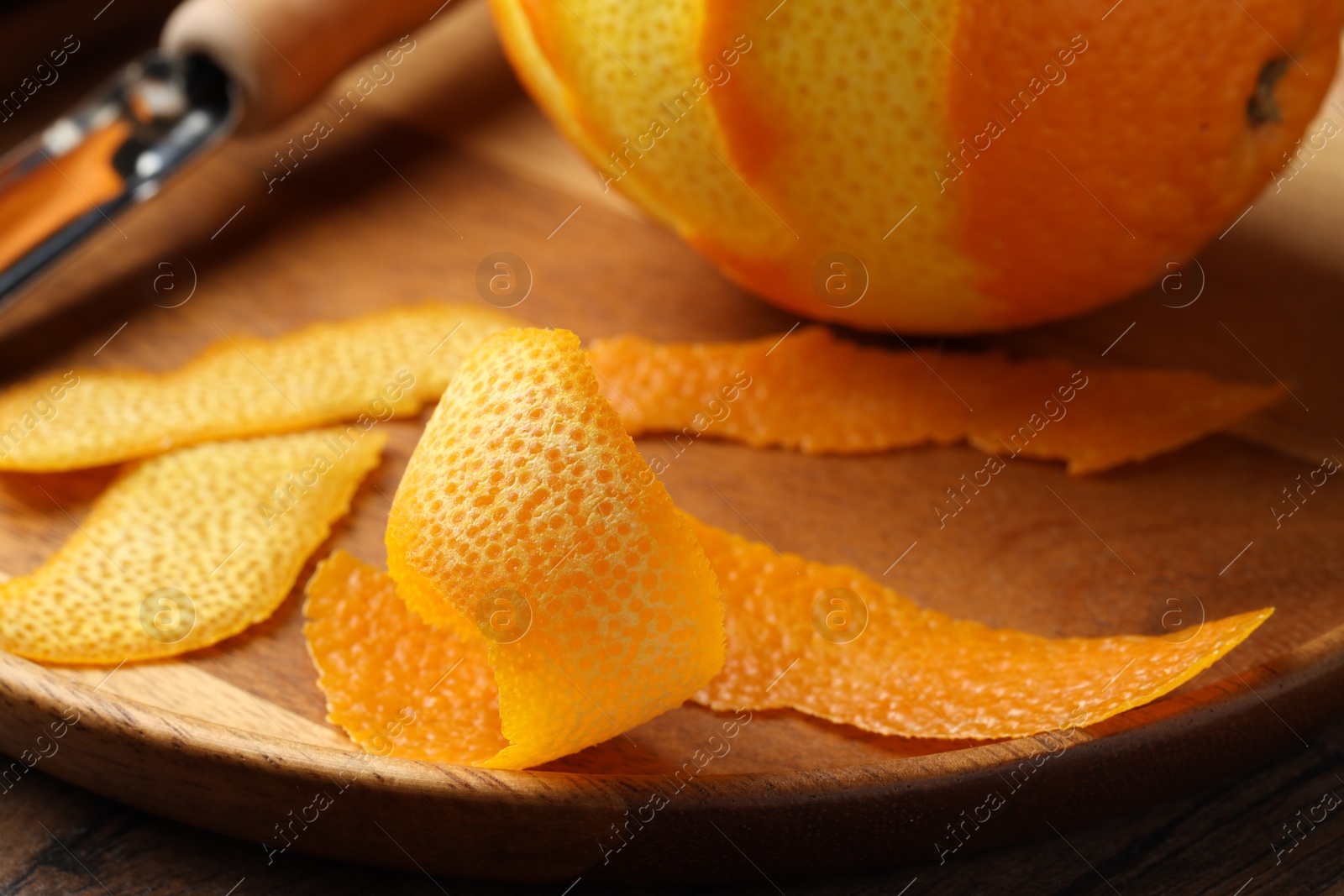 Photo of Fresh orange peel and fruit on wooden table, closeup