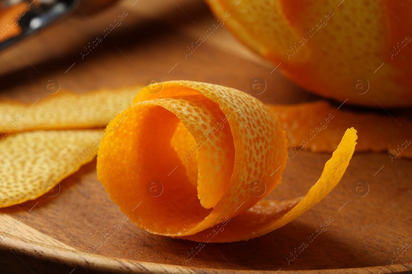 Photo of Fresh orange peel and fruit on wooden table, closeup