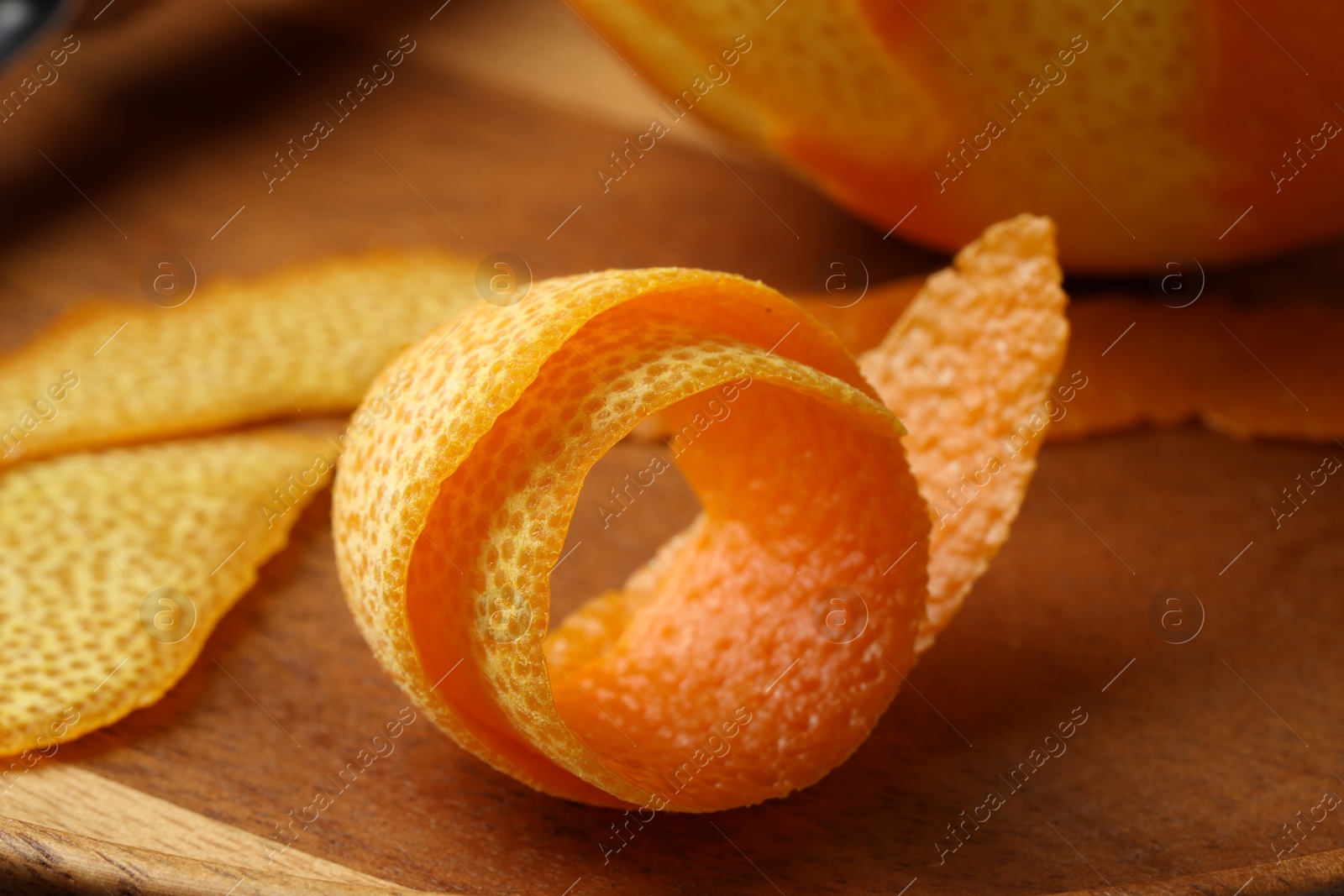 Photo of Fresh orange peel and fruit on wooden table, closeup