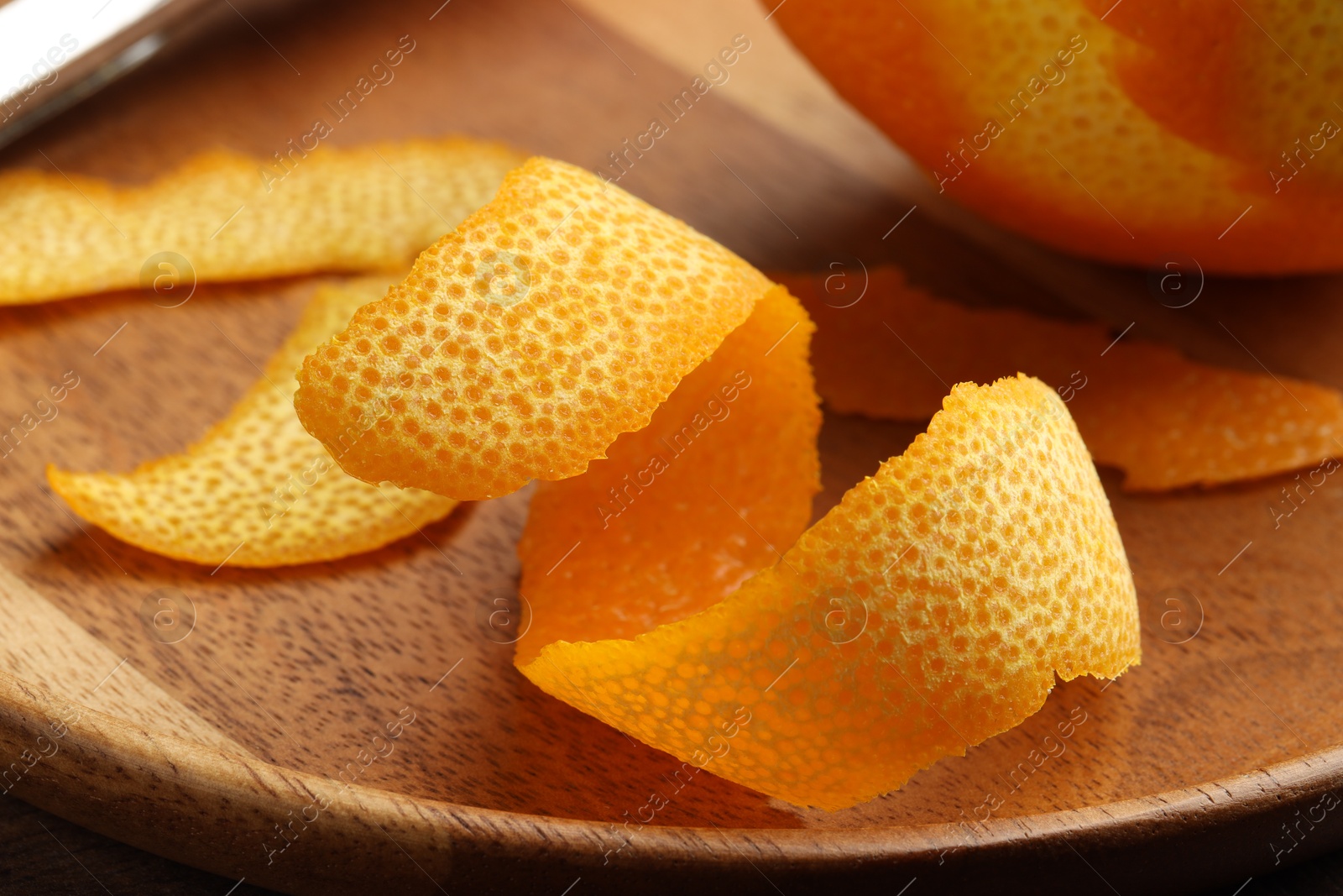 Photo of Fresh orange peel and fruit on wooden table, closeup