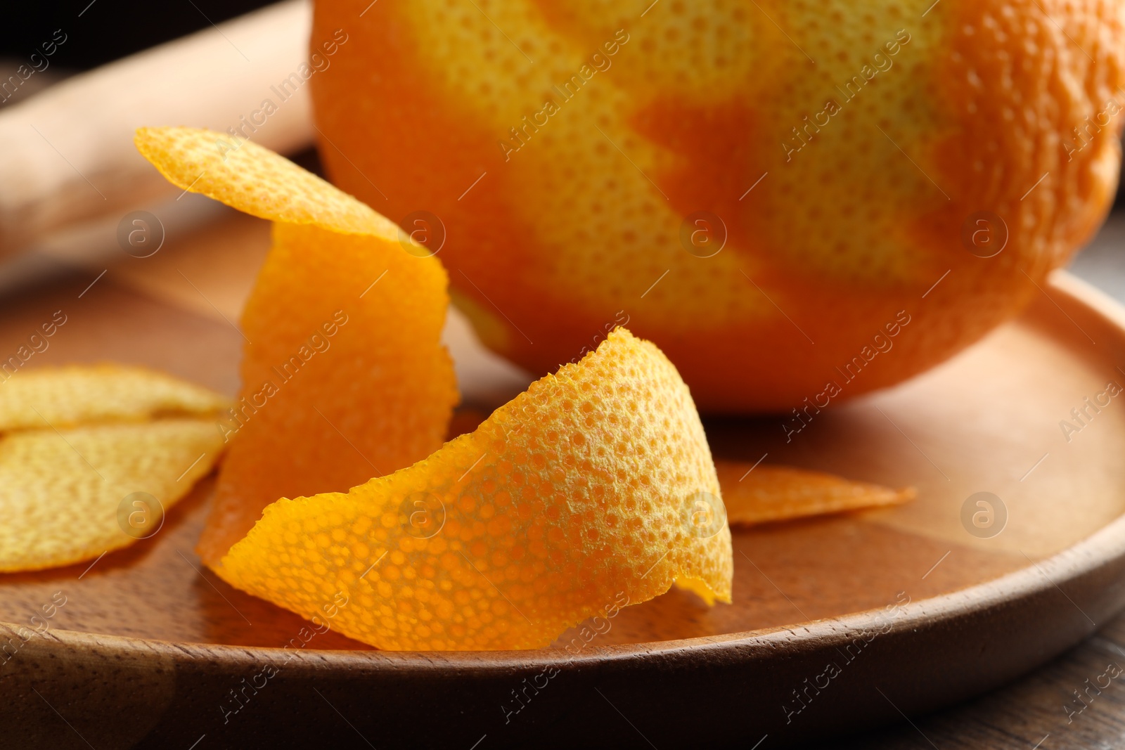 Photo of Fresh orange peel and fruit on wooden table, closeup