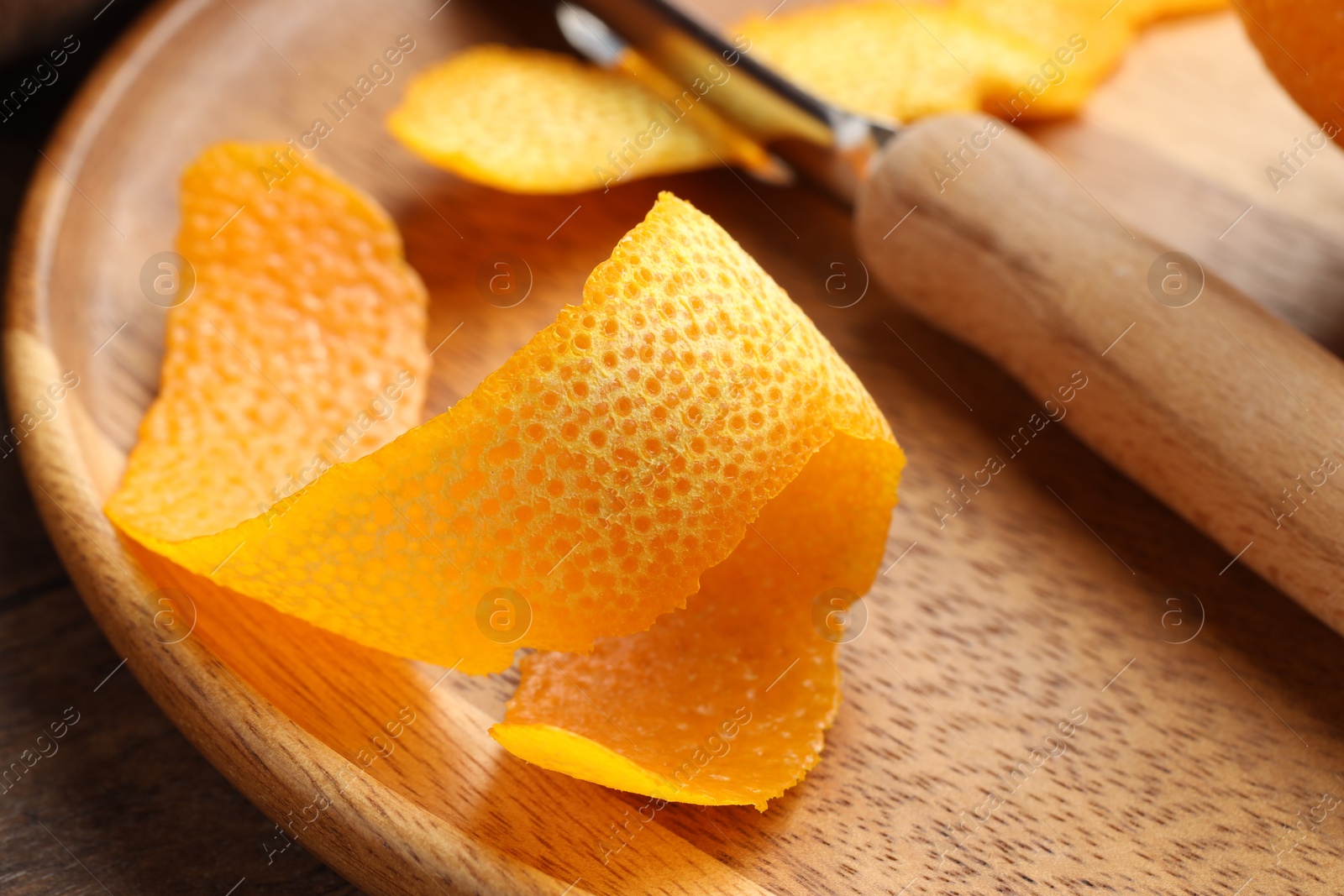 Photo of Fresh orange peel on wooden table, closeup