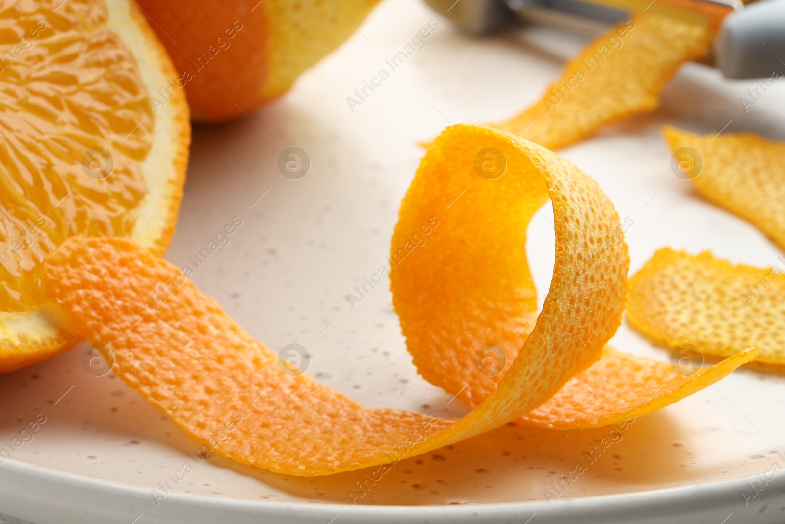 Photo of Fresh orange peel and fruit on light table, closeup