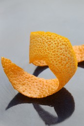 Photo of Fresh orange peel on dark table, closeup